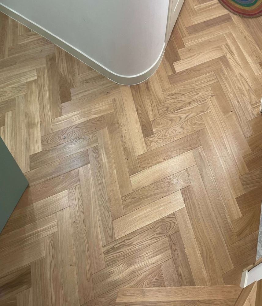 Zdjęcie z góry prezentujące efekty montażu drewnianego parkietu dębowego ze wzorem w jodełkę.
