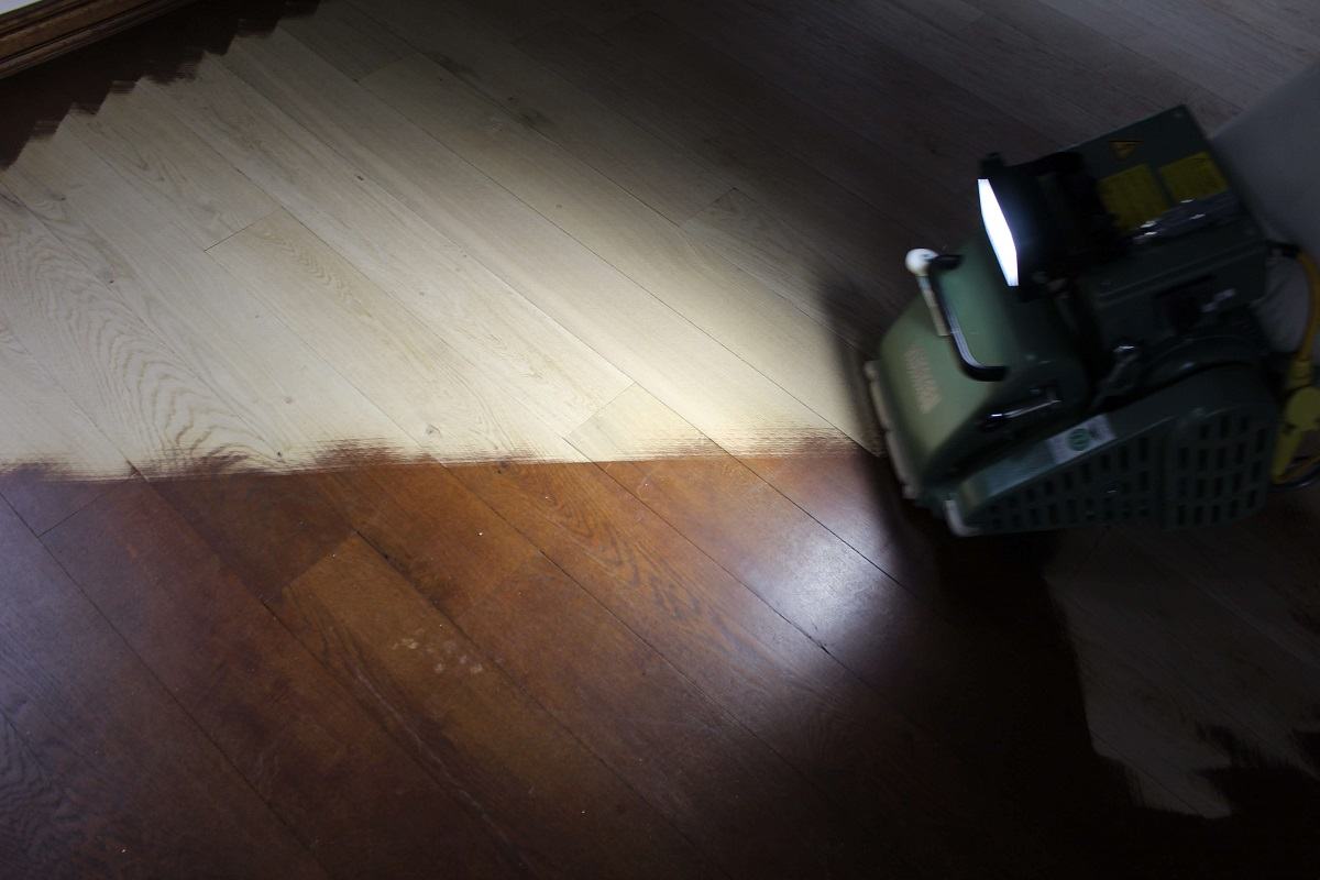 Zdjęcie pokazuje fragment dębowej podłogi, na której widać porównanie, jak prezentuje się podłoga wycyklinowana oraz ta przed zabiegiem renowacji.