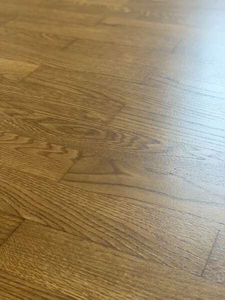 Zdjęcie prezentuje podłogę z drewna dębowego, gdzie deski tworzą wzór pokładowy. Podłoga została poddana zabiegowi cyklinowaniu oraz koloryzowaniu.
