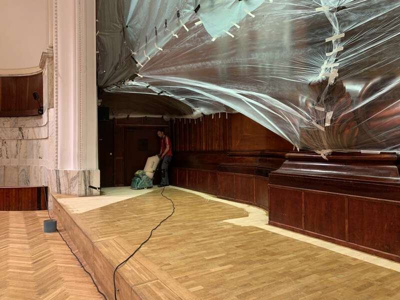 Zdjęcie przedstawia scenę Filharmonii Narodowej, na której jeden z naszych specjalistów wykonuje zabieg cyklinowania podłogi.