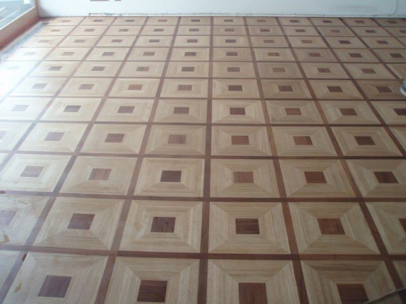 Zdjęcie przedstawia parkiet pałacowy o wzorze przypominającym drewnianą mozaikę. Parkiet pokryty jest matowym lakierem.